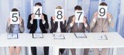 Portrait of confident business people showing score cards